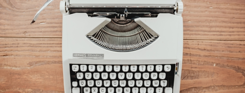 white and black typewriter on table
